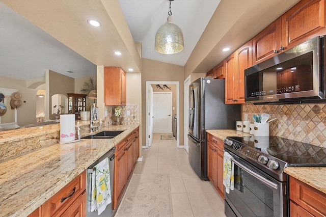 kitchen with sink, decorative light fixtures, light tile patterned floors, stainless steel appliances, and light stone countertops