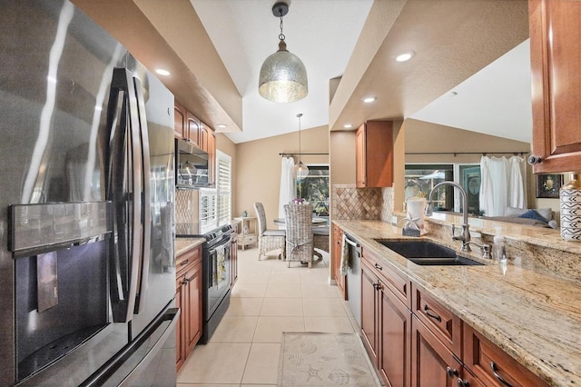 kitchen featuring lofted ceiling, appliances with stainless steel finishes, sink, and hanging light fixtures