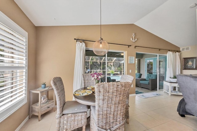 tiled dining space featuring vaulted ceiling