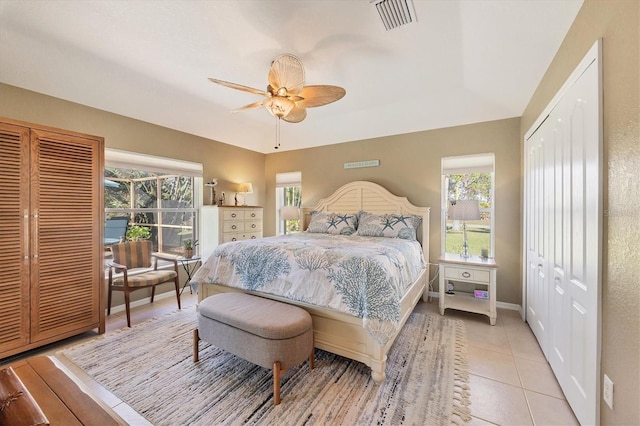 bedroom with multiple windows, light tile patterned floors, and ceiling fan