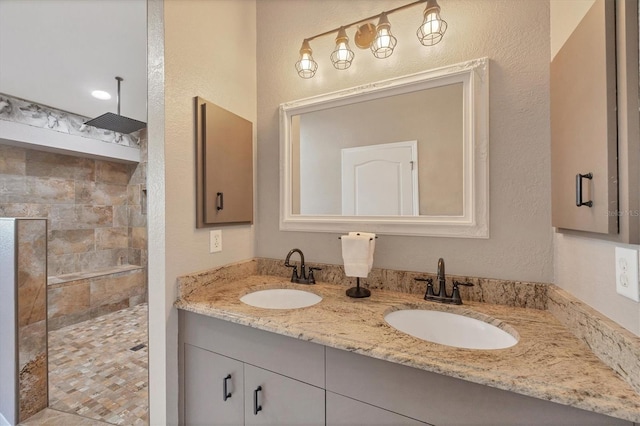 bathroom with vanity and tiled shower