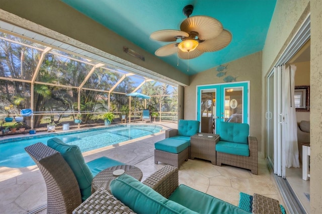 view of swimming pool with an outdoor living space, ceiling fan, glass enclosure, and a patio area