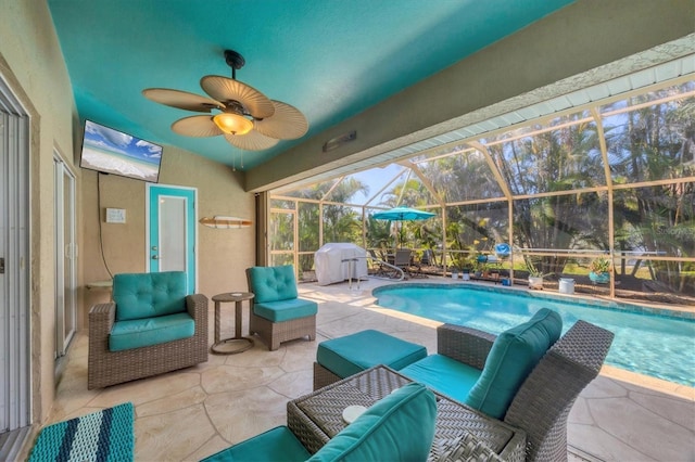 view of swimming pool with a patio area, an outdoor hangout area, ceiling fan, and glass enclosure