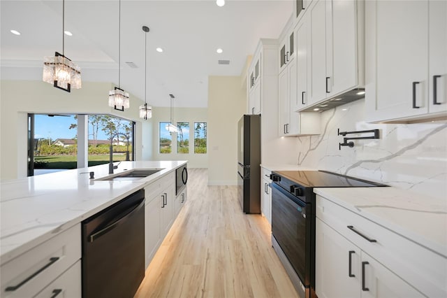 kitchen featuring pendant lighting, backsplash, light stone countertops, black appliances, and white cabinets