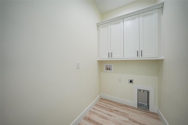 clothes washing area featuring hookup for a washing machine, electric dryer hookup, cabinets, and light hardwood / wood-style floors