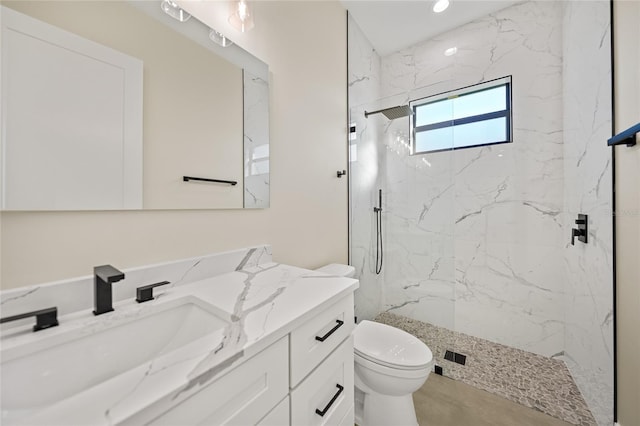 bathroom with vanity, toilet, and a tile shower