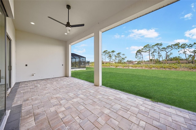 view of patio featuring ceiling fan and glass enclosure