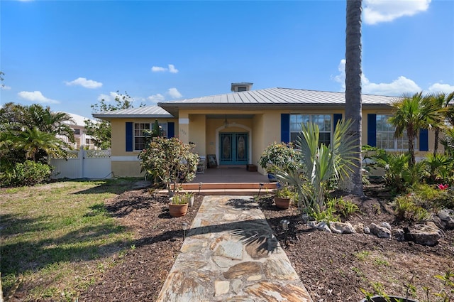 view of front facade with a front lawn and french doors