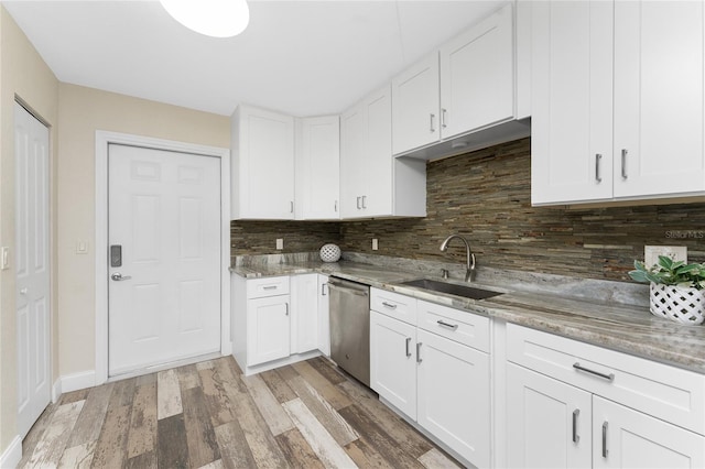 1313 Buereau Rd, Englewood, FL 34223 - kitchen featuring a sink, decorative backsplash, dishwasher, white cabinets, and light stone countertops