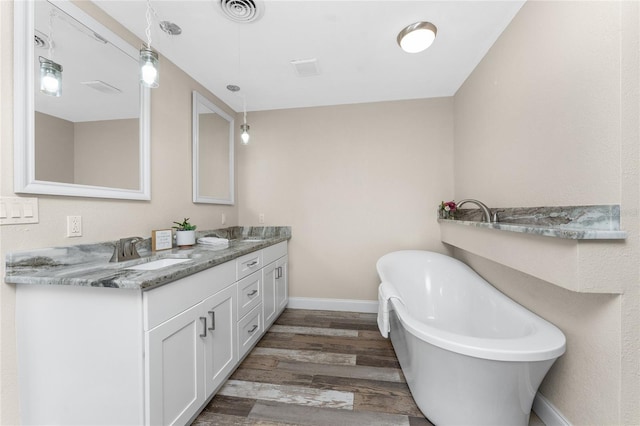1313 Buereau Rd, Englewood, FL 34223 - full bathroom featuring double vanity, wood finished floors, visible vents, a sink, and a soaking tub