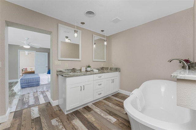 1313 Buereau Rd, Englewood, FL 34223 - ensuite bathroom with wood finished floors, a sink, double vanity, a freestanding bath, and visible vents