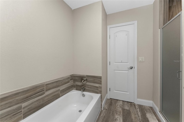 1313 Buereau Rd, Englewood, FL 34223 - bathroom featuring baseboards, a garden tub, wood finished floors, and a shower stall