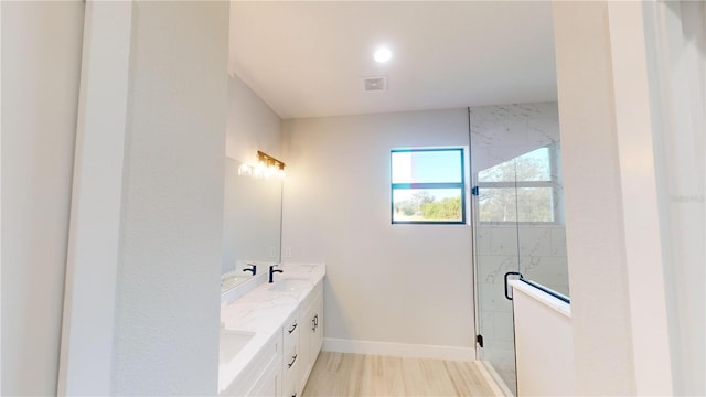 bathroom with hardwood / wood-style flooring, vanity, and an enclosed shower