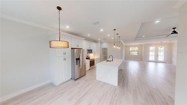 kitchen with sink, white cabinetry, decorative light fixtures, stainless steel appliances, and a large island