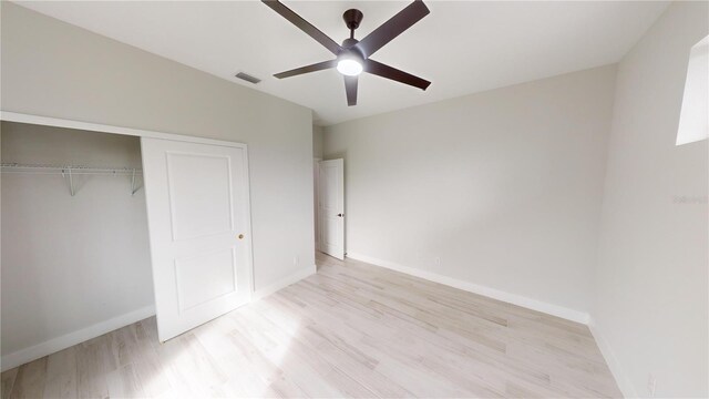 unfurnished bedroom with light hardwood / wood-style floors, a closet, and ceiling fan