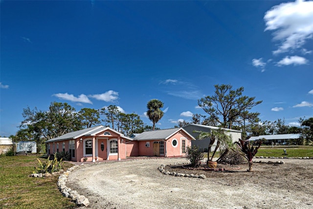 view of front of property featuring driveway and metal roof