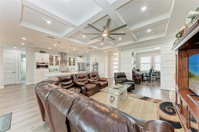 living room featuring light hardwood / wood-style floors, ceiling fan, coffered ceiling, beamed ceiling, and crown molding