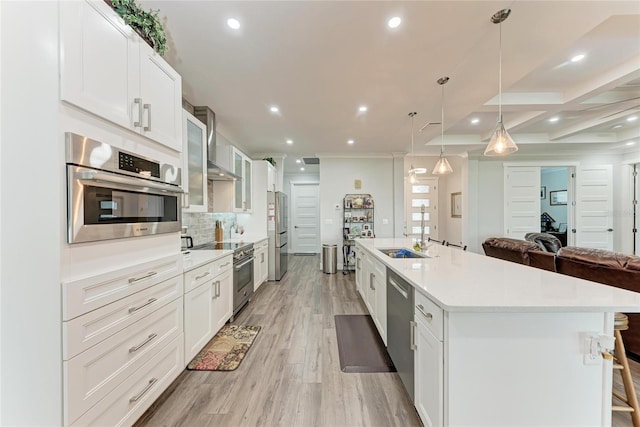 kitchen featuring white cabinets, appliances with stainless steel finishes, a breakfast bar, and pendant lighting