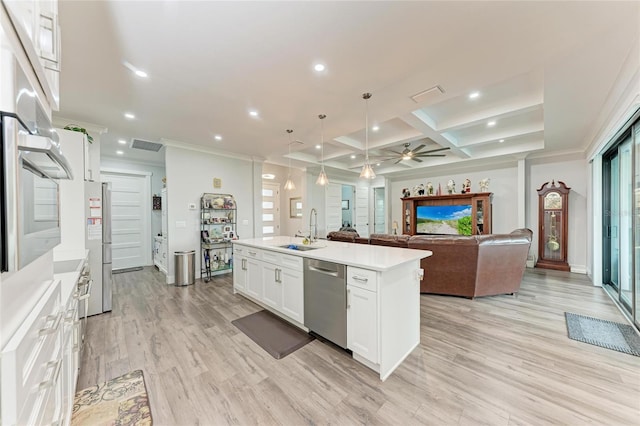 kitchen featuring appliances with stainless steel finishes, white cabinets, pendant lighting, sink, and a kitchen island with sink