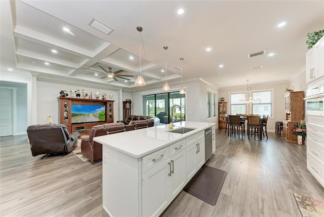 kitchen with white cabinetry, a center island with sink, sink, stainless steel dishwasher, and pendant lighting