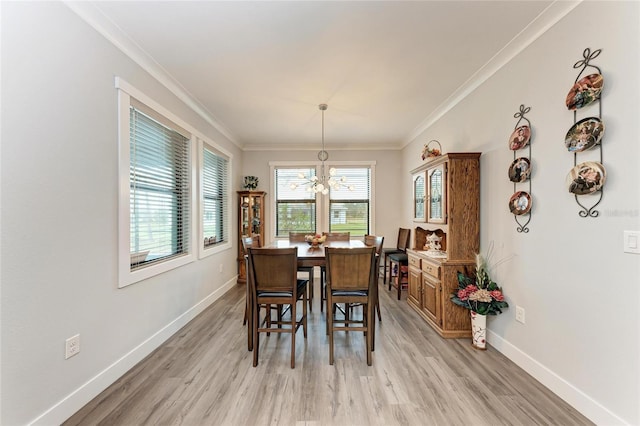 dining room featuring a notable chandelier, light hardwood / wood-style floors, and ornamental molding