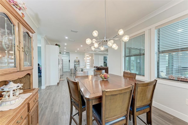 dining area with crown molding and light hardwood / wood-style floors