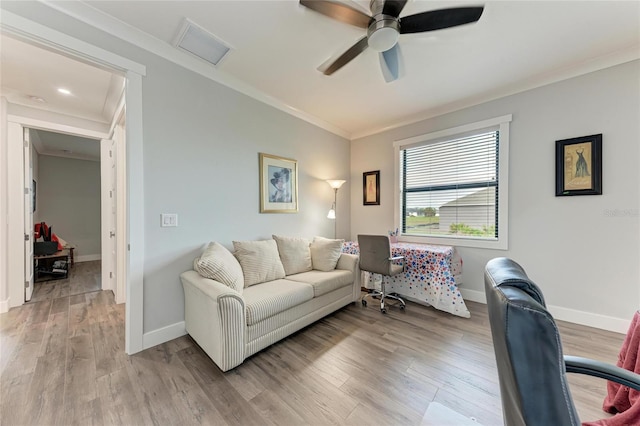 living room with ceiling fan, light wood-type flooring, and crown molding