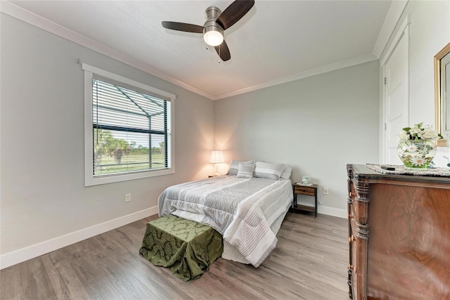 bedroom with ceiling fan, crown molding, and light hardwood / wood-style floors