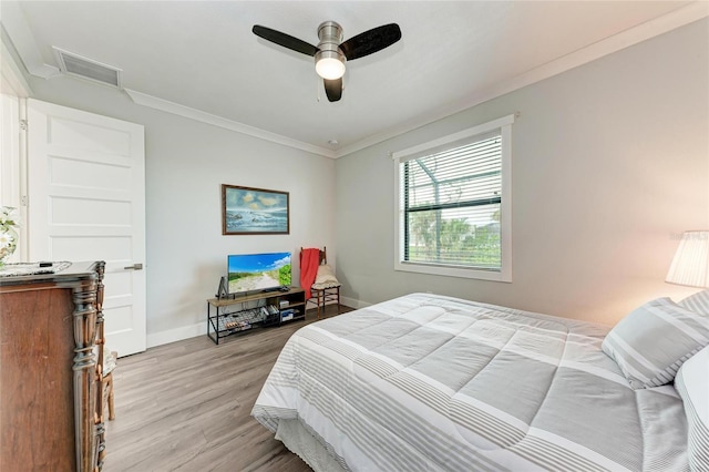 bedroom with ceiling fan, light hardwood / wood-style flooring, and crown molding