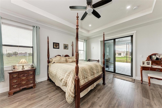 bedroom featuring ceiling fan, a raised ceiling, access to exterior, and hardwood / wood-style floors