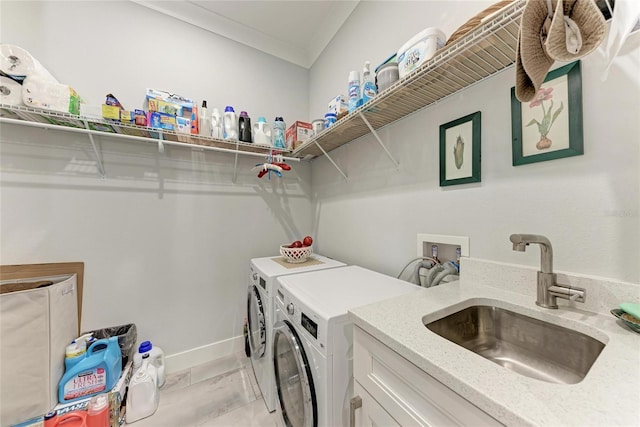 washroom with washing machine and dryer, sink, and crown molding