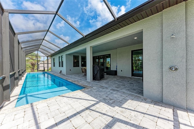 view of pool featuring a patio and glass enclosure