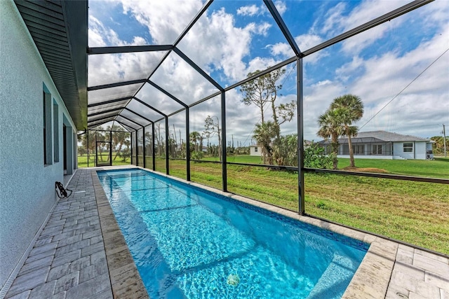 view of pool with a lawn, a patio, and a lanai