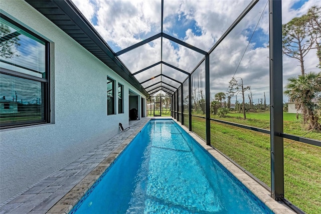 view of pool featuring glass enclosure and a lawn