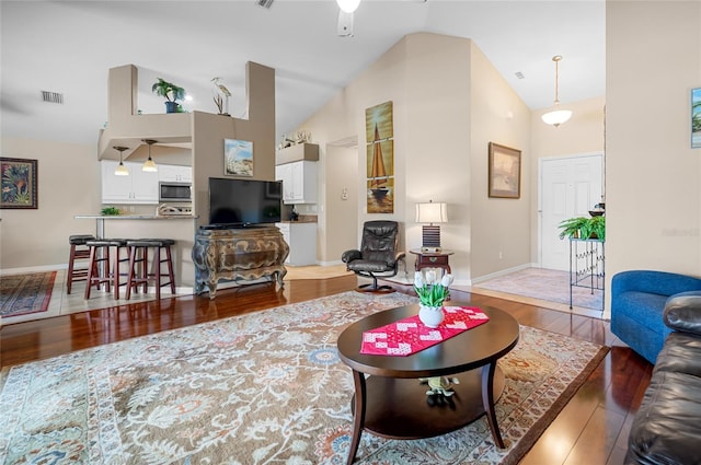 living room with dark wood-type flooring, high vaulted ceiling, and ceiling fan