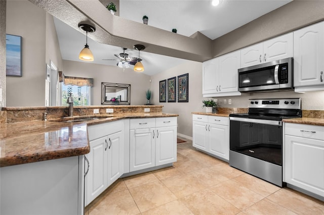 kitchen with sink, white cabinetry, hanging light fixtures, dark stone countertops, and stainless steel appliances