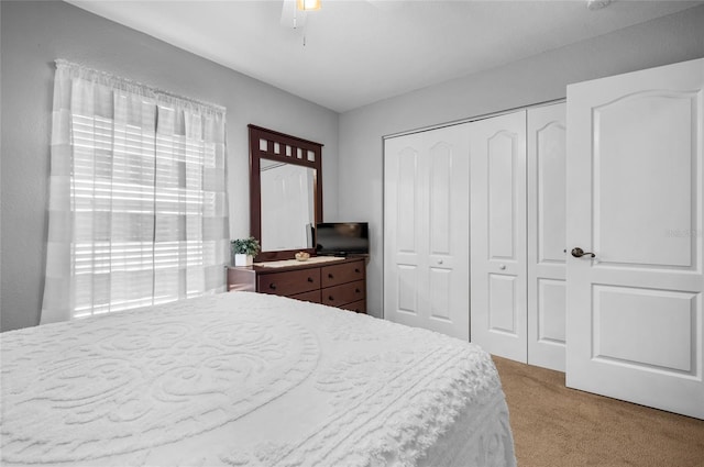 carpeted bedroom featuring ceiling fan and a closet