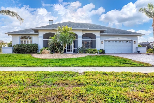 view of front of property with a garage and a front lawn