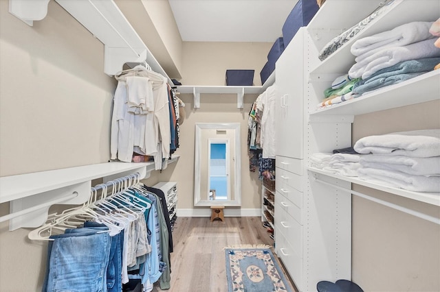 walk in closet with light hardwood / wood-style floors