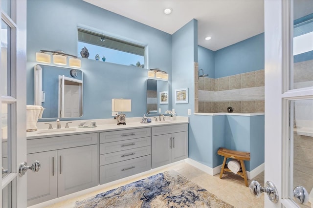 bathroom with tile patterned flooring, a shower, and vanity