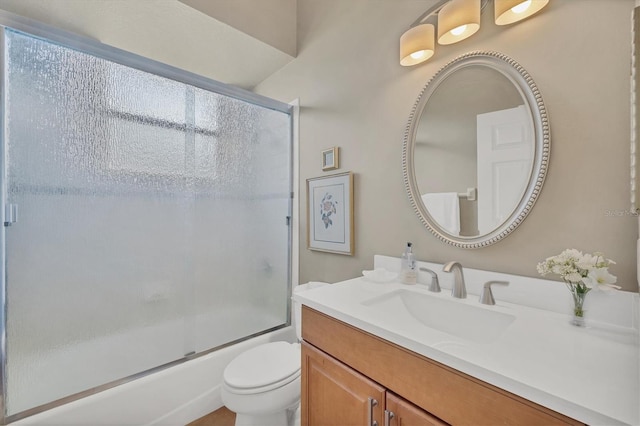 full bathroom featuring vanity, shower / bath combination with glass door, and toilet