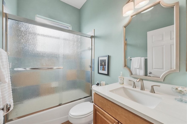 full bathroom featuring vanity, shower / bath combination with glass door, and toilet