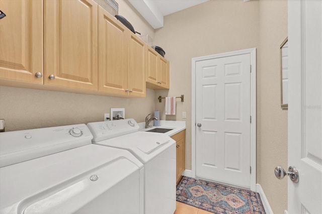 washroom with cabinets, washer and dryer, sink, and tile patterned floors