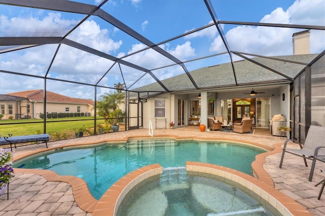 view of pool with a patio area, glass enclosure, an in ground hot tub, ceiling fan, and an outdoor living space