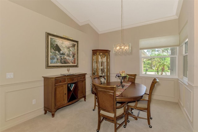 dining space featuring light carpet, vaulted ceiling, ornamental molding, and a decorative wall