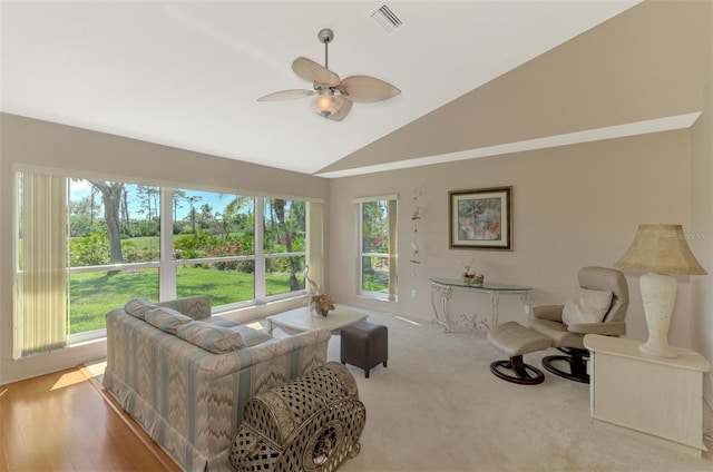 living area featuring visible vents, vaulted ceiling, and ceiling fan