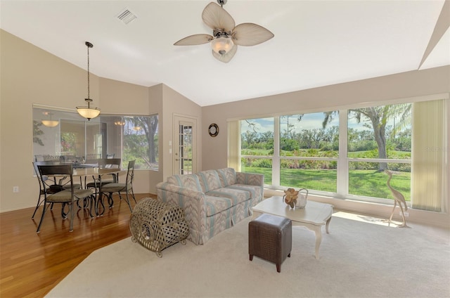 living area featuring vaulted ceiling, ceiling fan, wood finished floors, and visible vents