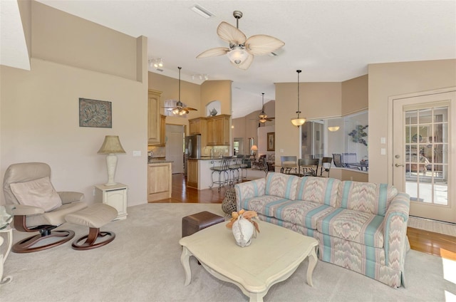 living room featuring ceiling fan, high vaulted ceiling, and visible vents