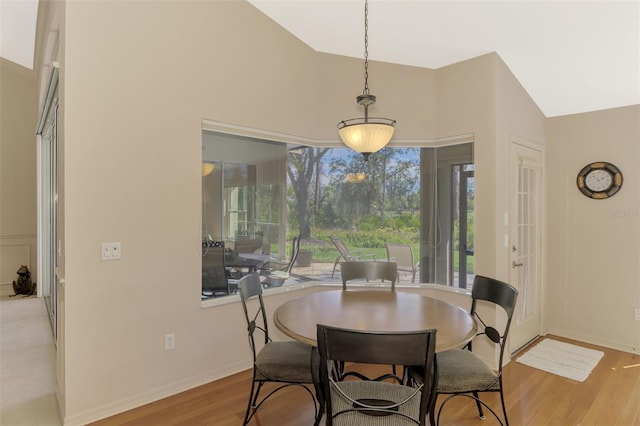 dining space with high vaulted ceiling, light wood-type flooring, and baseboards