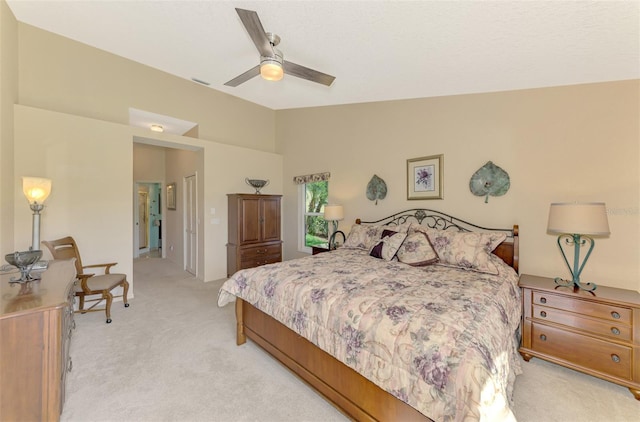 bedroom with vaulted ceiling, ceiling fan, and light carpet